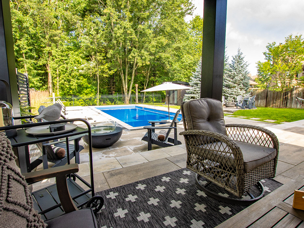 An outdoor family room, in combination with an Imagine Pools fiberglass swimming pool